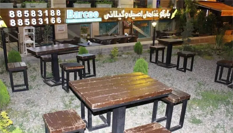فضای باز رستوران گیلانی بارکو با چیدمان دلنشین میز و صندلی‌های چوبی، محیطی آرام و مناسب برای تجربه‌ای به یادماندنی از غذاهای گیلانی.