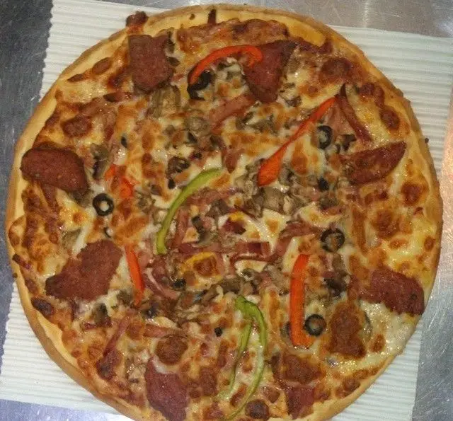 پیتزا هیزم با سوسیس، کالباس، قارچ، زیتون و فلفل دلمه ای، غذایی خوشمزه و پرطرفدار از فست فود هیزم. لذت طعم واقعی پیتزا.