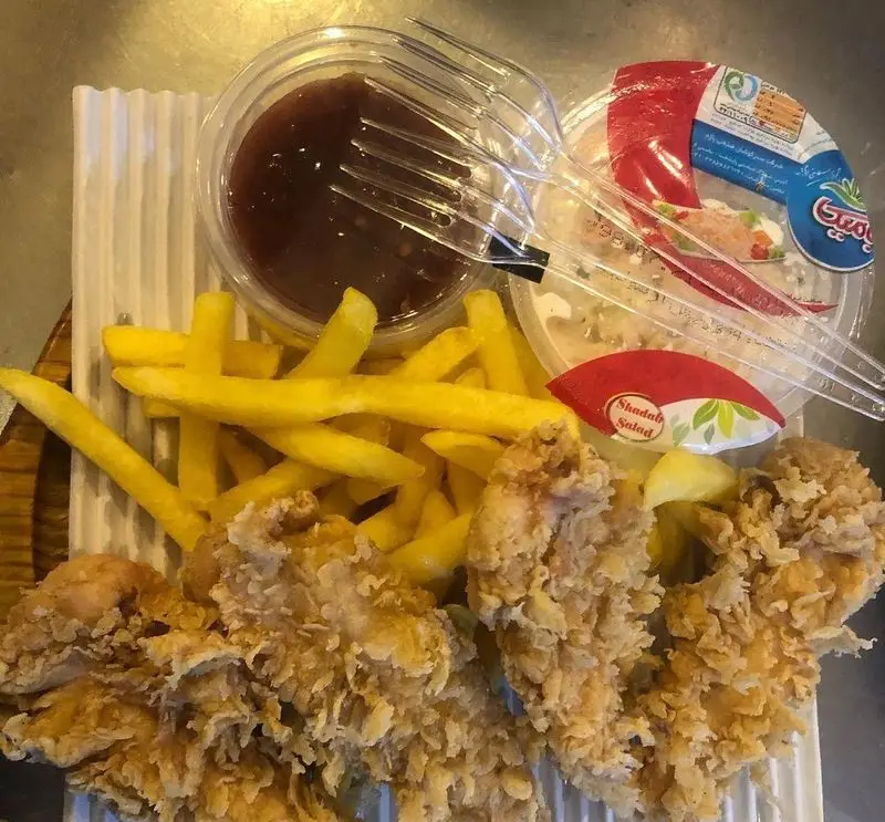 غذای فست فودی هیزم: فیله سوخاری کریسپی، سیب زمینی سرخ کرده طلایی، سس مخصوص و سالاد شاداب. یک وعده کامل و لذیذ.