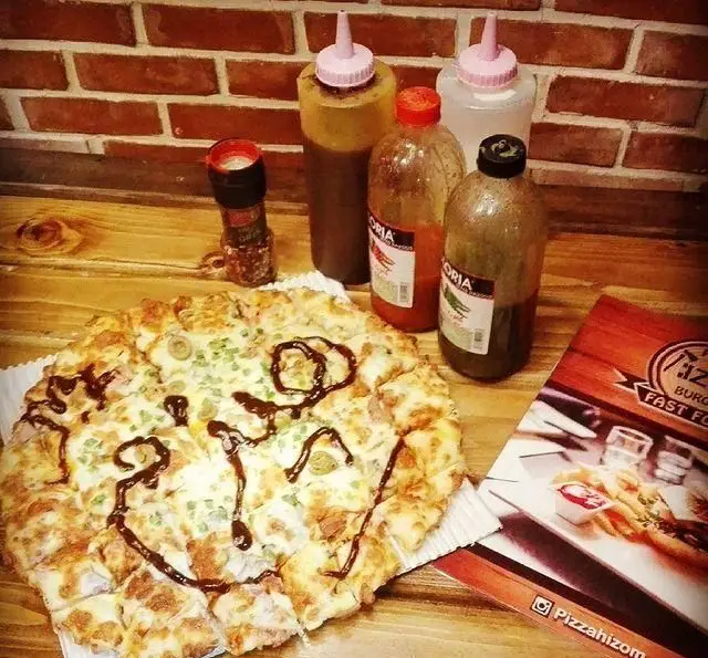 تصویری از پیتزای داغ و تازه هیزم با طرح هیزم روی آن، به همراه انواع سس‌های دلپذیر و منوی فست فود هیزم در محیط رستوران.