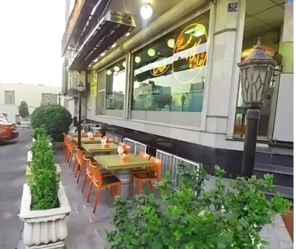 فضای بیرونی رستوران خانه کباب طهران در تهران، شامل میز و صندلی‌های شیک برای سرو غذا در محیطی سرسبز و آرام.