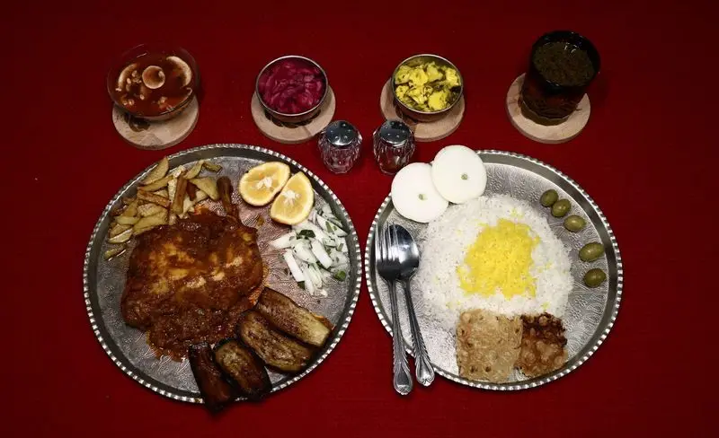 مطبخ فر و دیگ: سفرهای کامل با پلو زعفرانی، مرغ مجلسی، بادمجان سرخ شده، سیبزمینی و مخلفات اصیل ایرانی مانند ترشی و سوپ.