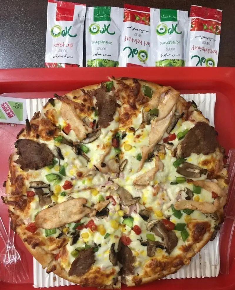 تصویر پیتزا مخلوط خوشمزه فست فود ستاره شب با مرغ، قارچ، گوشت، ذرت و فلفل دلمه رنگارنگ، سرو شده با سس‌های الو.