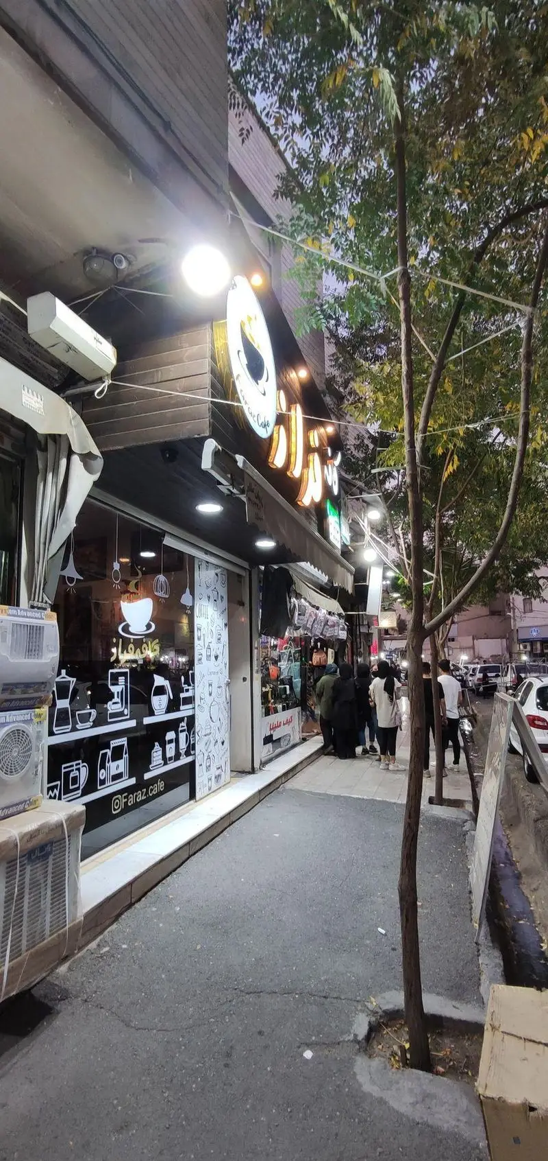 کافه فراز (Faraz Cafe) در شب، با نورپردازی محیطی دلنشین، پاتوقی دنج برای علاقه‌مندان به قهوه با طرح‌های خاص روی شیشه.