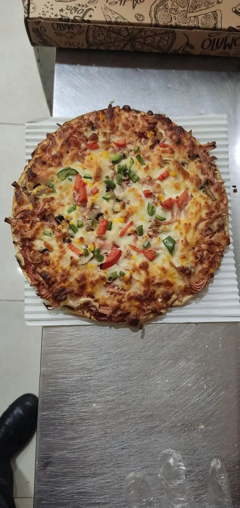 پیتزا پرملات و خوشمزه با پنیر آب شده، فلفل دلمه‌ای، گوجه، ذرت و قارچ، آماده سرو در فست‌فود و پیتزا فروشی برگر. تجربه‌ای لذیذ از پیتزای داغ.