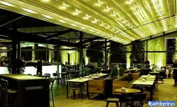 تصویری از فضای داخلی کافه رستوران لول ۴ در شب، با سقف نورانی و میز و صندلی‌های شیک، محیطی دلنشین برای صرف غذا و نوشیدنی.