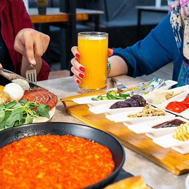 میز صبحانه مفصل و متنوع در کافه رستوران لول ۴، شامل املت، سوسیس، تخم مرغ آبپز، آب پرتقال و مخلفات تازه. تجربه‌ای لذت‌بخش.