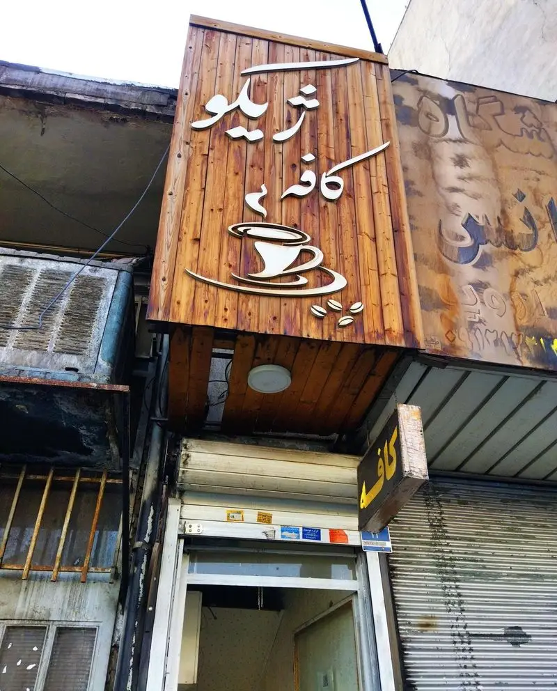 نمای بیرونی کافه ژیکو با تابلو چوبی و طراحی فنجان قهوه، یک کافی شاپ دنج با محیط گرم برای دوستداران قهوه در شهر.