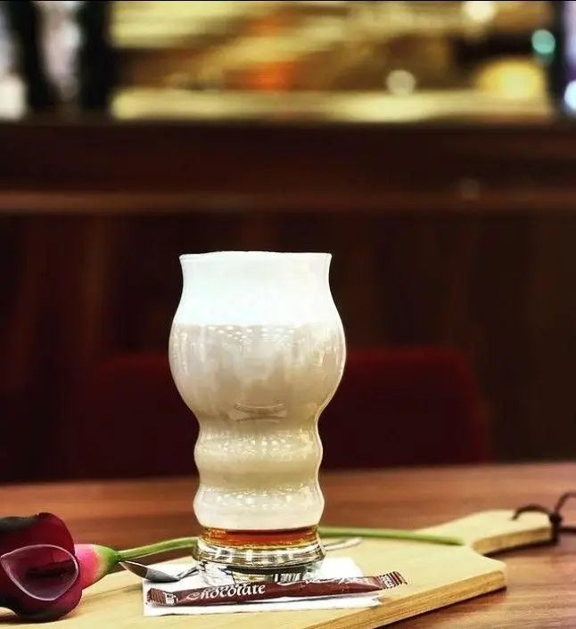 یک نوشیدنی لاته یا قهوه شکلاتی با فوم شیر، در لیوانی خاص و شیک. سرو اختصاصی کافی شاپ امیرشکلات، برای تجربه ای دلپذیر در فضایی دنج.