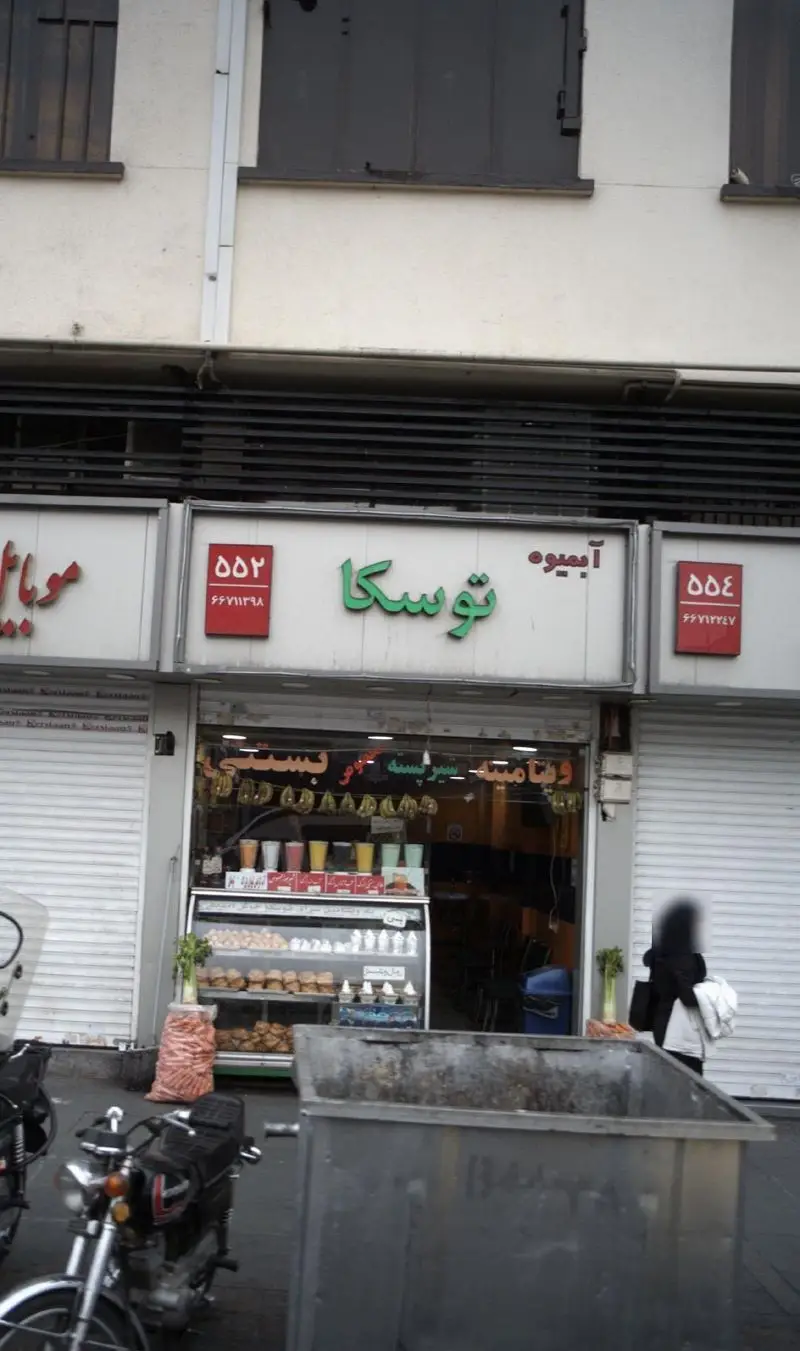 نمای بیرونی آبمیوه و بستنی توسکا با تابلوی سبز رنگ و ویترین پر از آبمیوه‌های تازه، بستنی و شیرینی‌های مختلف.