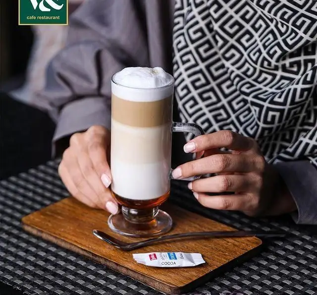 یک لیوان قهوه لایه ای ماکیاتو با فوم خامه ای در کافه رستوران لومیر. لذت نوشیدن نوشیدنی های گرم و دلپذیر را در فضای شیک و آرام لومیر تجربه کنید.