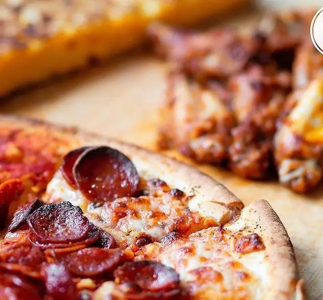 پیتزا پپرونی ویژه کافه رستوران لومیر، آماده برای سرو در کنار انواع بال مرغ و ساید دیش‌های خوشمزه و باکیفیت ما.