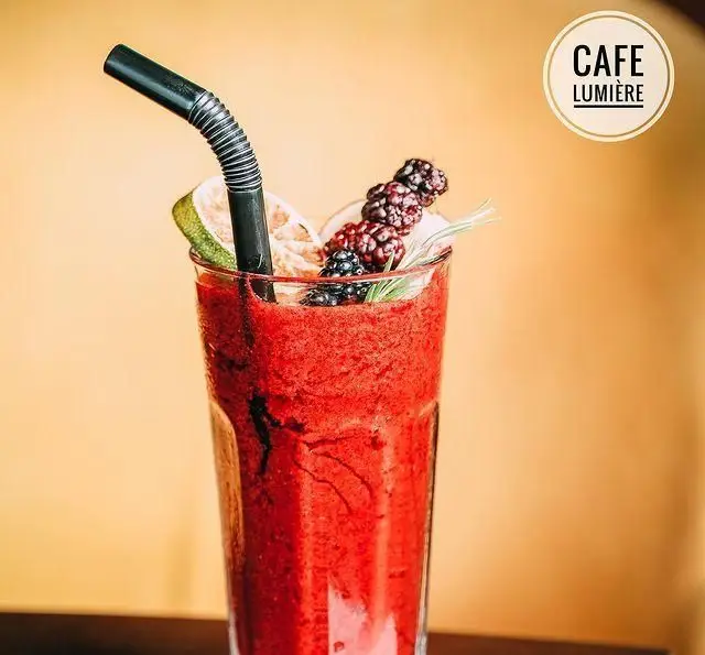 اسموتی قرمز رنگ و هیجان‌انگیز میوه‌ای با تزئین تمشک و لیمو در کافه لومیر. نوشیدنی خنک و گوارا در فضای دلنشین کافه رستوران لومیر.