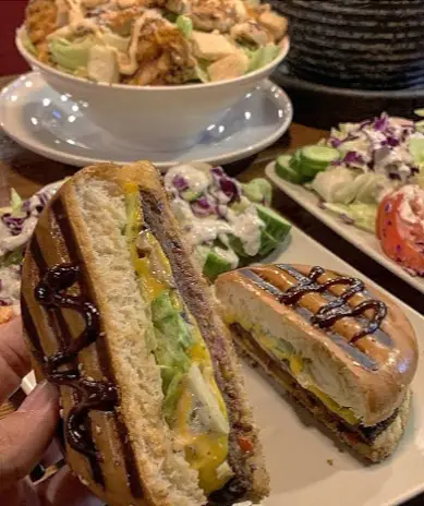 تصویری از ساندویچ گریل شده خوشمزه با آووکادو و پنیر، همراه با سالاد در کافه رستوران لومیر، یک وعده غذایی عالی.