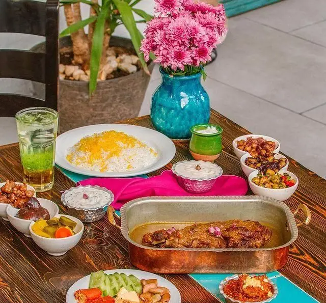 یک وعده غذای کامل گیلکی در رستوران بهزاد شامل ران گوسفند آبدار، برنج زعفرانی، زیتون پرورده و دیگر مخلفات شمالی.