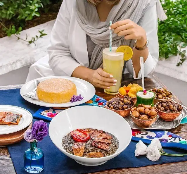 میز غذای گیلکی متنوع در رستوران بهزاد، شامل ته چین، خورش، ماهی و مخلفات گوناگون در محیطی دلنشین برای تجربه‌ای اصیل.