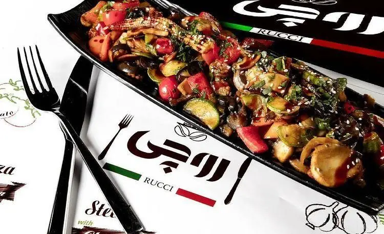 تصویری جذاب از بشقاب سبزیجات گریل متنوع و تازه در رستوران ایتالیایی روچی، با لوگوی برند روی رومیزی و چیدمان زیبا.