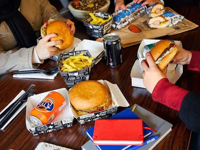 دورهمی دوستانه در برگرلند با صرف برگرهای لذیذ، سیب زمینی سرخ کرده طلایی، هات داگ و نوشیدنی‌های خنک برای تجربه فست فود.