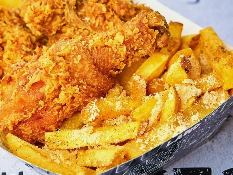 مرغ سوخاری ترد و خوشمزه برگرلند با سیب زمینی وجز طلایی و پنیر پارمزان، انتخابی عالی برای یک وعده فست فود لذیذ.