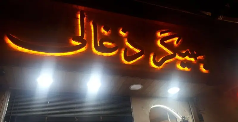 تابلوی زیبا و نورانی جگرکی جیگر ذغالی با فونت فارسی درخشان نارنجی، نمای شب یک کبابسرای سنتی ایرانی برای بهترین کباب جگر