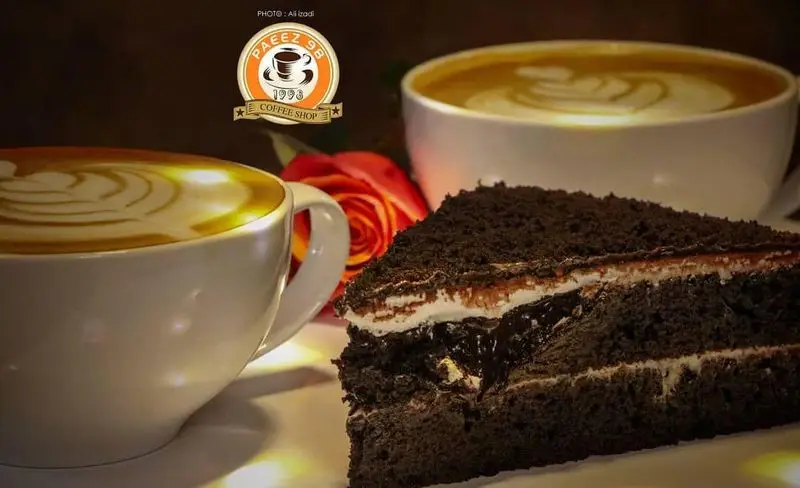 دو فنجان قهوه لاته با طرح لاته آرت و یک برش کیک شکلاتی خوشمزه در کافی شاپ پاییز ۹۸، ایده‌آل برای یک استراحت دلپذیر.