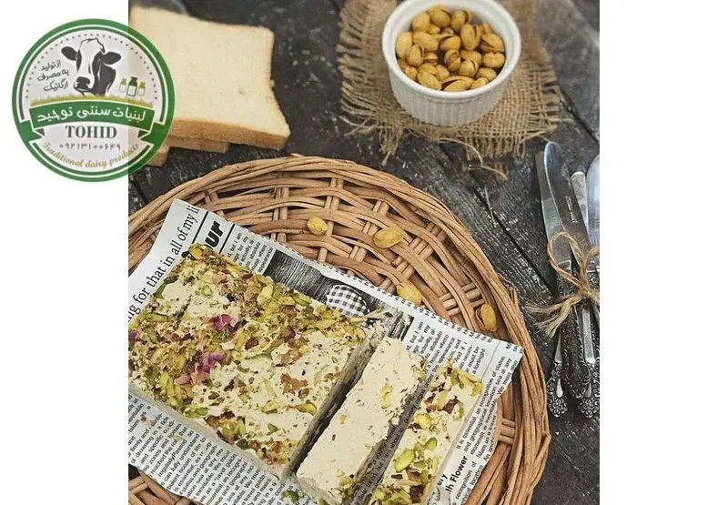 حلوای سنتی پر پسته لبنیات سنتی برادران، سرو شده روی سبد حصیری با نان تازه و آجیل. غذایی سالم و ارگانیک.