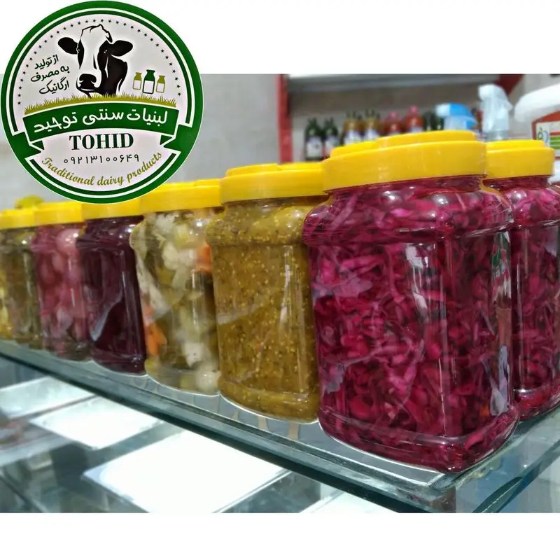 نمایی از ردیف جارهای ترشی و شور سنتی و خوشرنگ در فروشگاه لبنیات سنتی برادران. محصولات ارگانیک و تازه برای مشتریان.