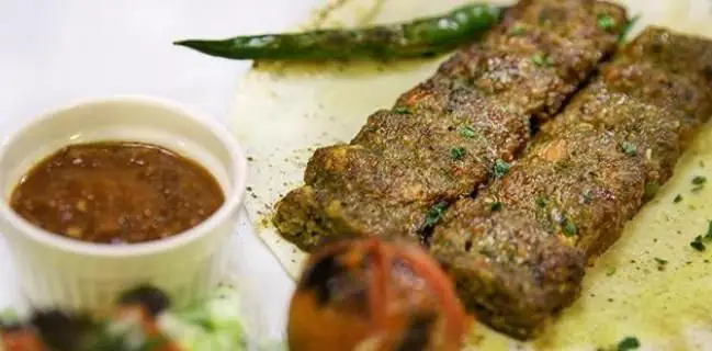 سینی کباب لذیذ جحینا با دو سیخ کباب گوشت، فلفل سبز تند، سس مخصوص و گوجه کبابی. غذای اصیل خاورمیانه در کافی شاپ جحینا.