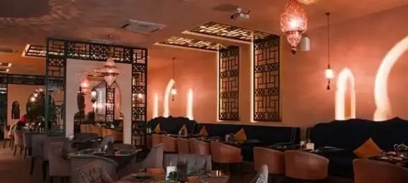 نمای داخلی کافی شاپ ایوان با طراحی سنتی و مدرن، نورپردازی گرم و فضایی آرامش‌بخش، مکانی ایده‌آل برای لذت بردن از قهوه و غذا در محیطی دلنشین.