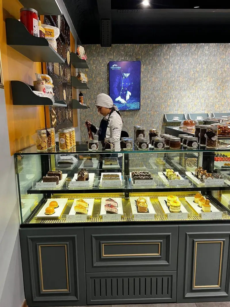 فروشگاه چوکوچاملی: ویترین جذاب و پر از کیک‌های تازه، چیزکیک، دسرهای خاص و شیرینی‌های لذیذ آماده برای مشتریان.