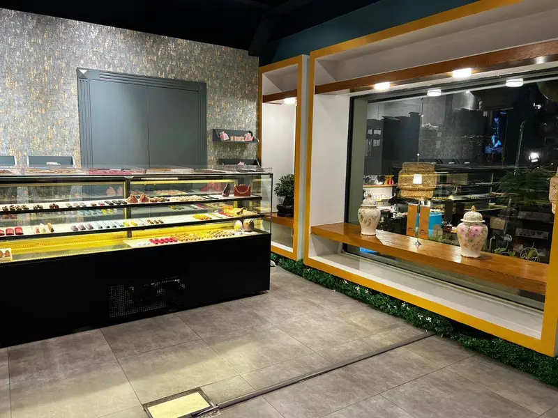 ویترین جذاب چوکوچاملی پر از انواع شکلات، شیرینی و دسرهای لوکس در محیطی مدرن و شیک. بهترین محصولات تازه و خوشمزه.