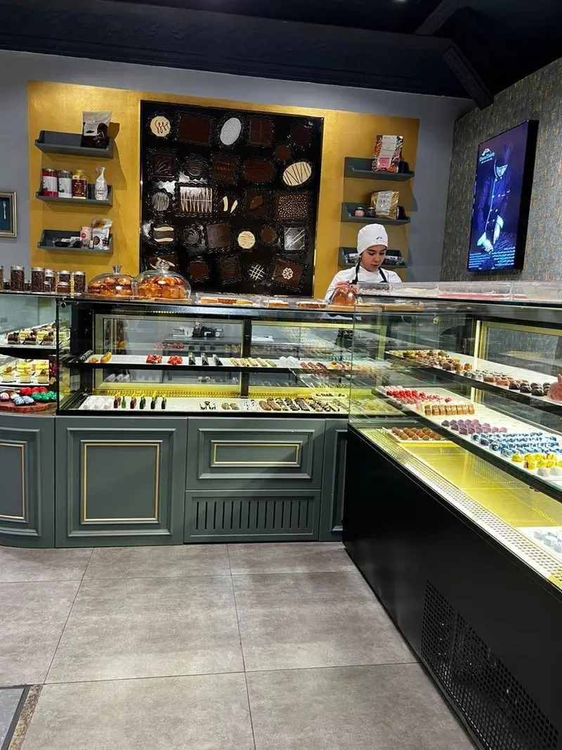 فروشگاه شیرینی و شکلات چوکوچاملی: ویترین‌های مدرن پر از انواع شکلات دست‌ساز، شیرینی و دسرهای تازه، با طراحی داخلی جذاب.