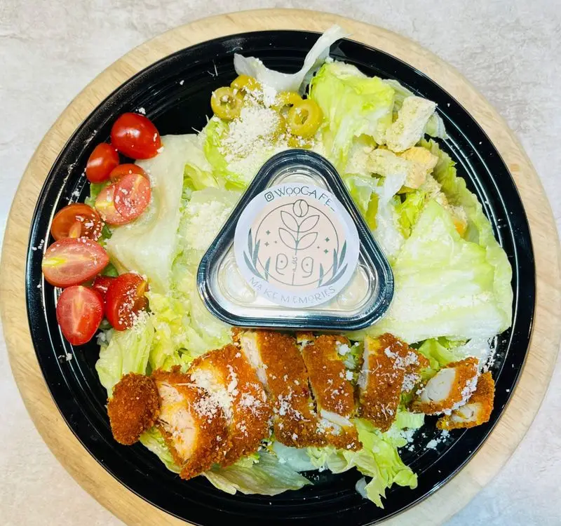 سالاد سزار پرطرفدار کافه وو با مرغ سوخاری ترد، گوجه گیلاسی، زیتون و کروتون. انتخابی سالم و دلچسب از WooCafe.