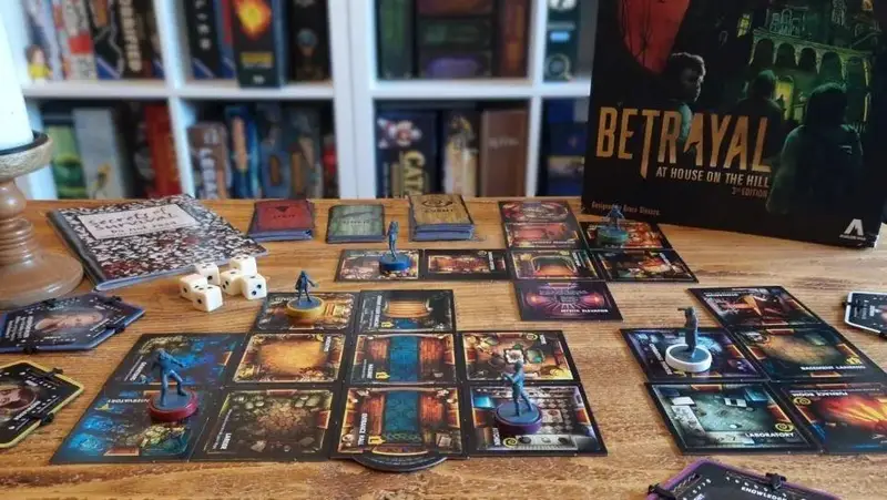 تصویری از بازی رومیزی Betrayal at House on the Hill 3rd Edition در کافه گیم اسپارت، نمایشگر مهره‌ها، تاس‌ها و کارت‌های بازی.