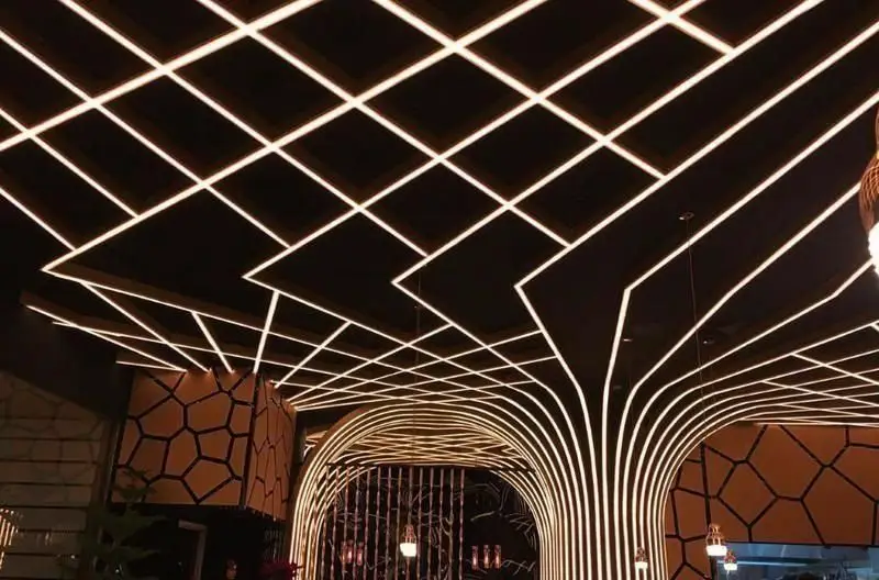 دکوراسیون داخلی مدرن و جذاب رستوران اکسون با نورپردازی خلاقانه سقف و طرح‌های هندسی زیبا، فضایی دلنشین برای مشتریان.
