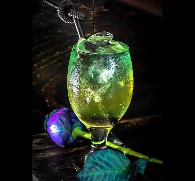 نوشیدنی خنک و گوارا در کافه ژوانی، کوکتل سبز با یخ و گل بنفش، تجربه‌ای دلنشین در فضایی آرام و مدرن.