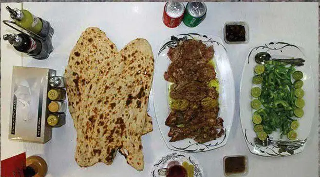 یک سفره کامل طباخی راک شامل کله‌پاچه لذیذ، نان سنگک برشته، سبزی خوردن تازه، لیمو، نوشیدنی و چاشنی‌ها.