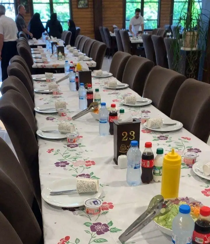 تصویری از میزهای چیدمان شده رستوران هانی با ظروف، نوشیدنی‌ها و غذا، آماده خدمت‌رسانی به مشتریان در فضایی دلنشین.