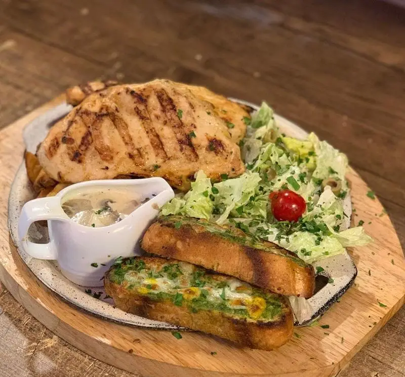 رستوران هانی: مرغ گریل آبدار با سس قارچ خوشمزه، سالاد فصل تازه و نان سیر پنیری تست شده، تجربه‌ای لذت‌بخش و سالم.