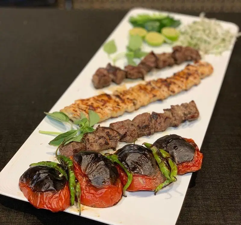 تصویری جذاب از سینی کباب میکس رستوران هانی شامل کباب برگ، کوبیده و جوجه. لذت چشیدن غذای اصیل ایرانی را با ما تجربه کنید.