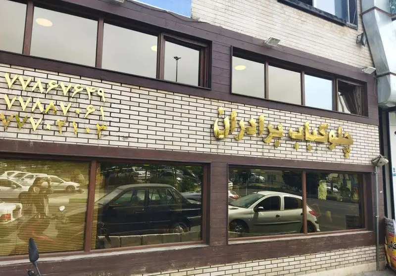 نمای بیرونی رستوران برادران، متخصص چلو کباب و غذای سنتی ایرانی. تابلوی برجسته با شماره تماس و طراحی آجری.