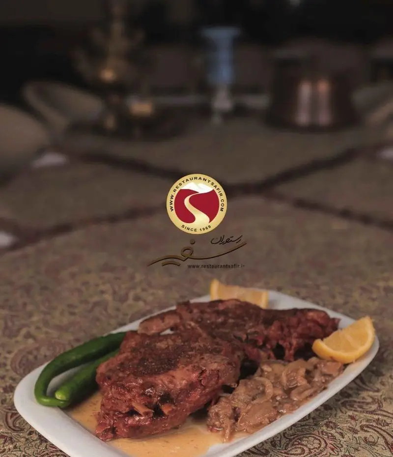 خوراک لذیذ گوشت پخته با سس مخصوص، همراه فلفل سبز، پیاز کاراملی و لیمو در رستوران سنتی سفیر.