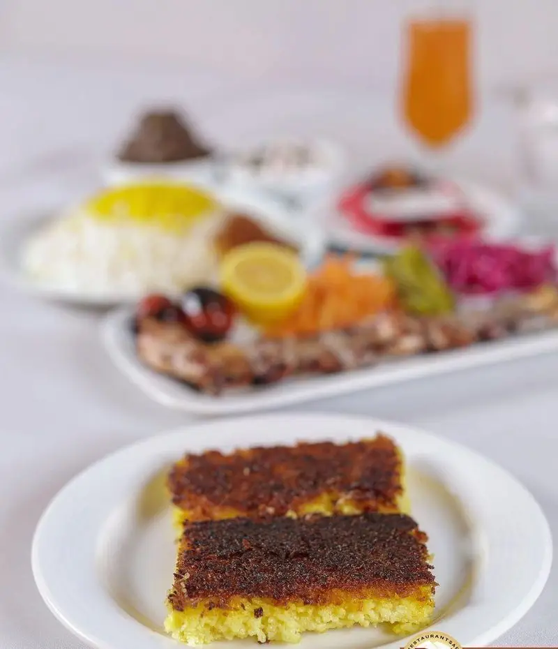 ته دیگ ترد و طلایی، کباب و برنج زعفرانی خوش عطر، همراه با مخلفات متنوع در رستوران سفیر. تجربه‌ای لذیذ از غذای اصیل ایرانی.