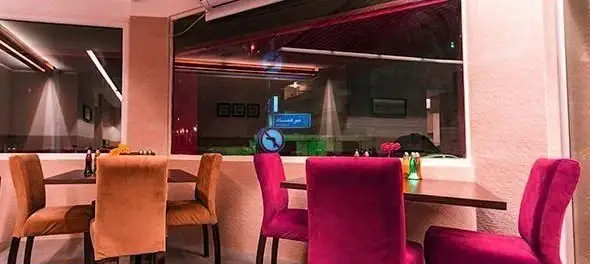 فضای داخلی دنج و دلنشین رستوران ایرانی میر عماد در شب، با چیدمان شیک میز و صندلی‌های راحت و دکوراسیونی گرم و جذاب.