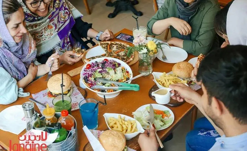 لذت دورهمی دوستانه در رستوران و کافه لانجین با منوی متنوعی از پیتزا، برگر، سالادهای رنگارنگ و سیب‌زمینی لذیذ.