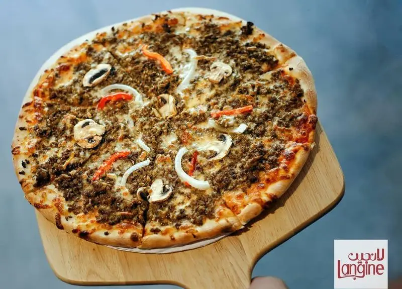 پیتزای گوشت و قارچ رستوران لانجین با پیاز و فلفل دلمه، سرو شده بر روی تخته چوبی، یک غذای خوشمزه و اشتهاآور.
