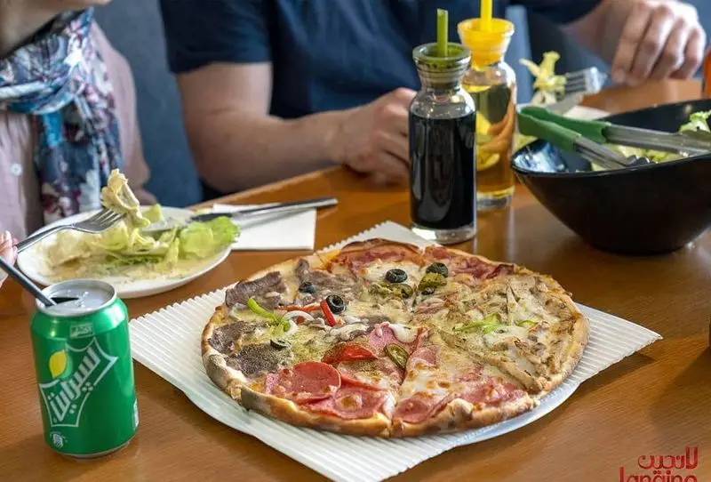 پیتزا چندطعم، سالاد تازه و نوشیدنی در رستوران و کافه لانجین. لذت یک وعده غذایی متنوع و خوشمزه در فضایی دلنشین.