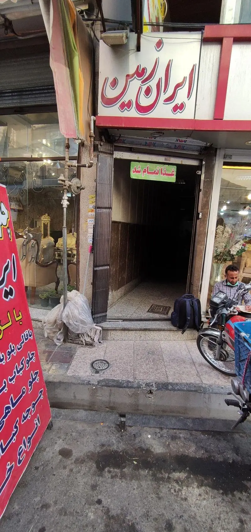 نمای بیرونی رستوران ایران زمین با تابلوی 'غذا تمام شد'. ارائه دهنده چلو کباب، باقالی پلو، جوجه کباب و انواع غذای ایرانی.