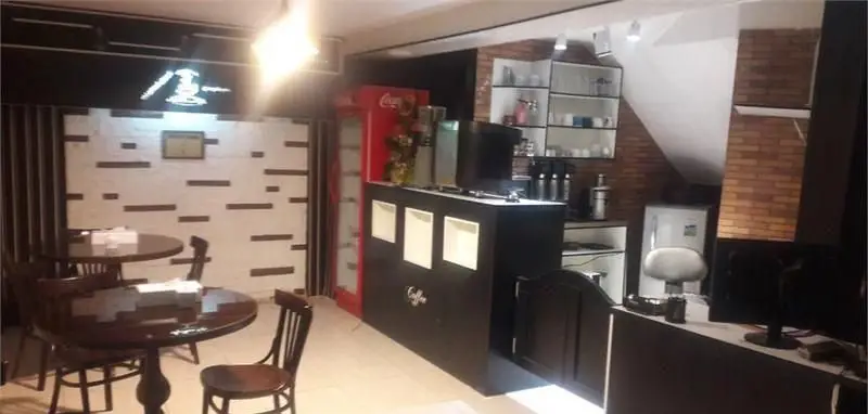 نمای داخلی کافه سفره خانه فارا با دکوراسیون مدرن و شیک، شامل میز و صندلی چوبی، پیشخوان قهوه و محیطی دلنشین برای مشتریان.