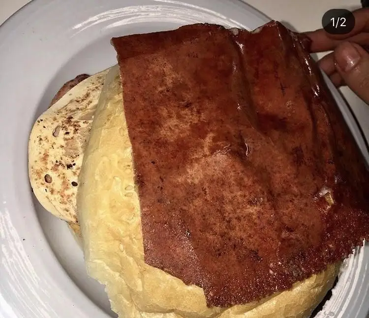 نمایی از ساندویچ فست فود کاردین با گوشت ورقه‌ای سرخ شده و نان برگر طلایی، انتخابی ایده‌آل برای یک وعده کامل و خوش‌طعم.